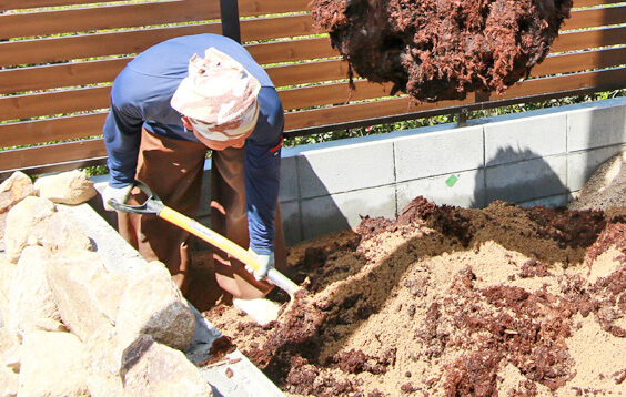 土を掘り、庭づくりの準備をする職人達